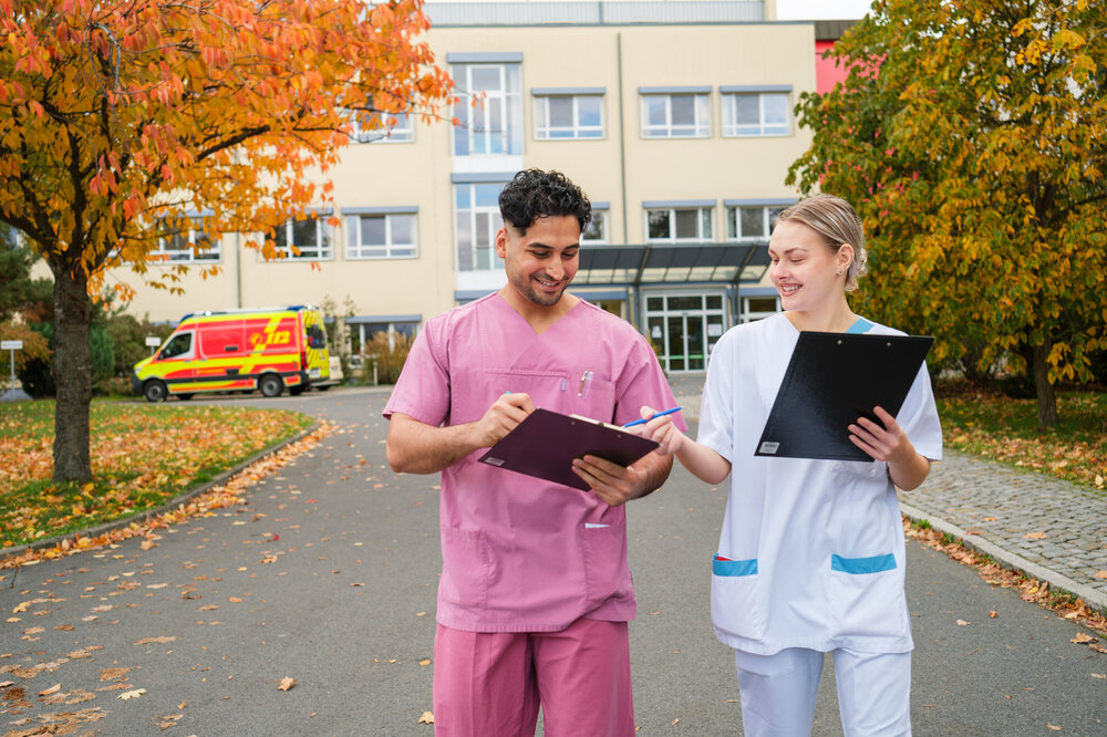 Pflegeschüler mit Pflegefachfrau im Gespräch